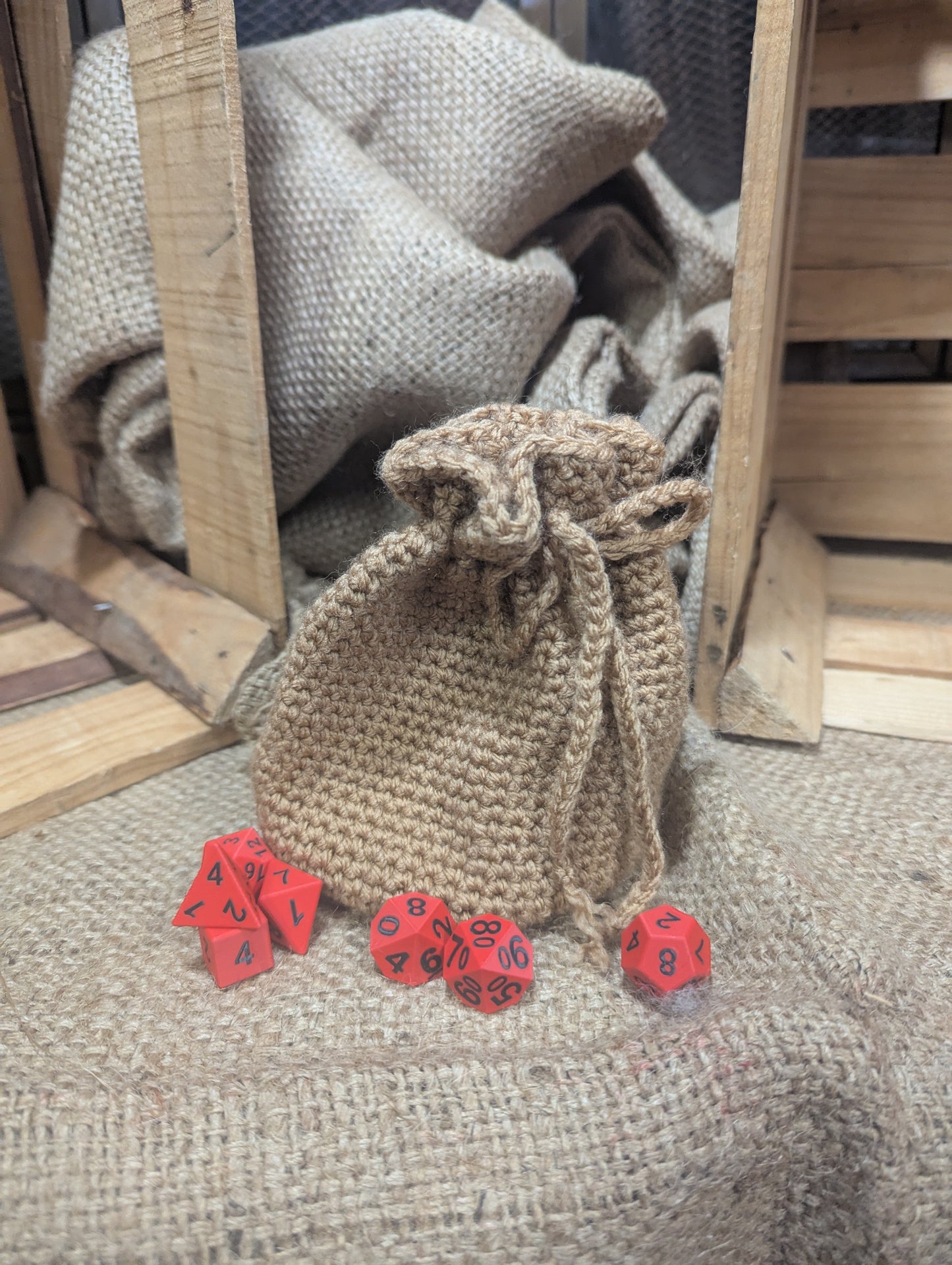 Burlap bag with red dice on a textured surface